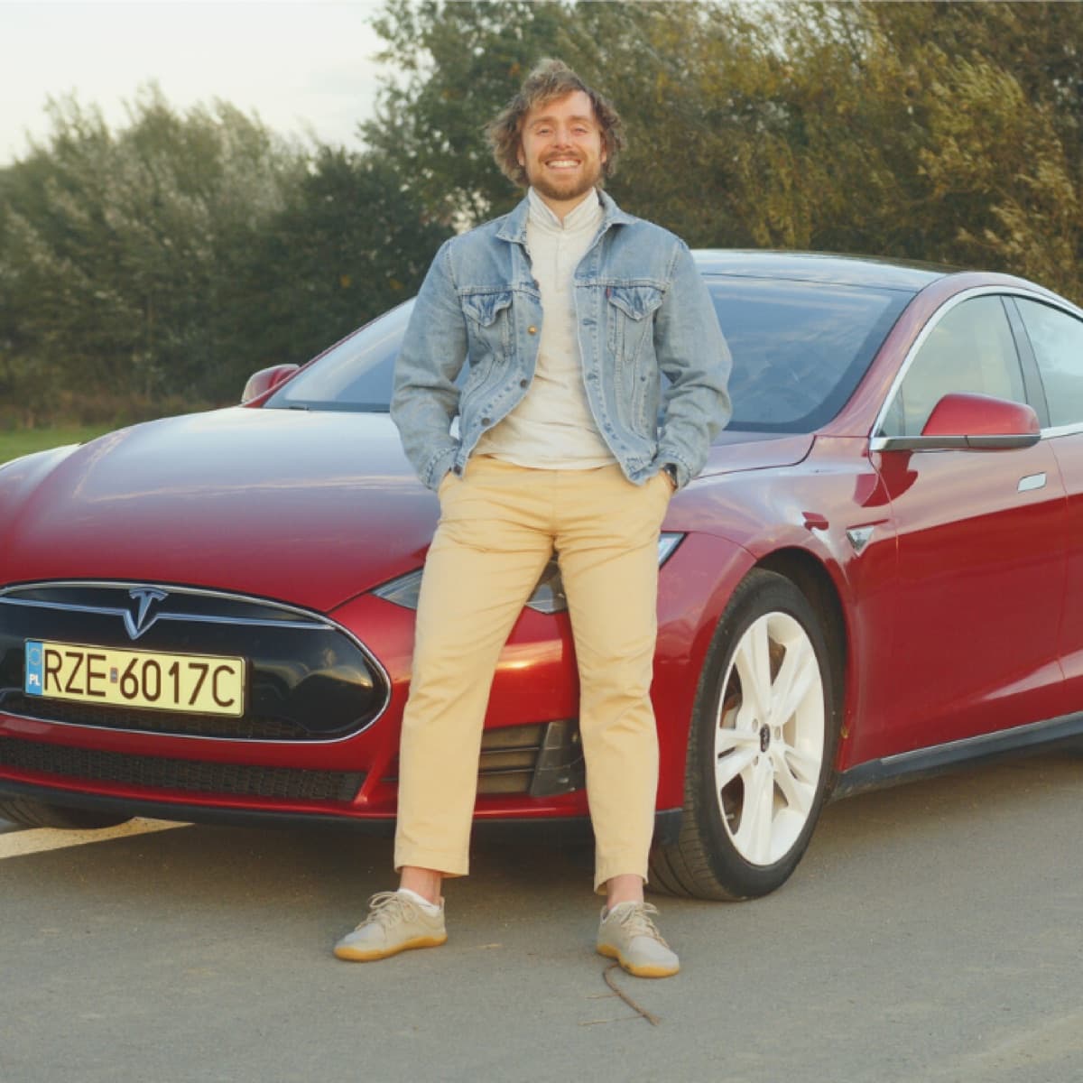 Łukasz standing by his Tesla